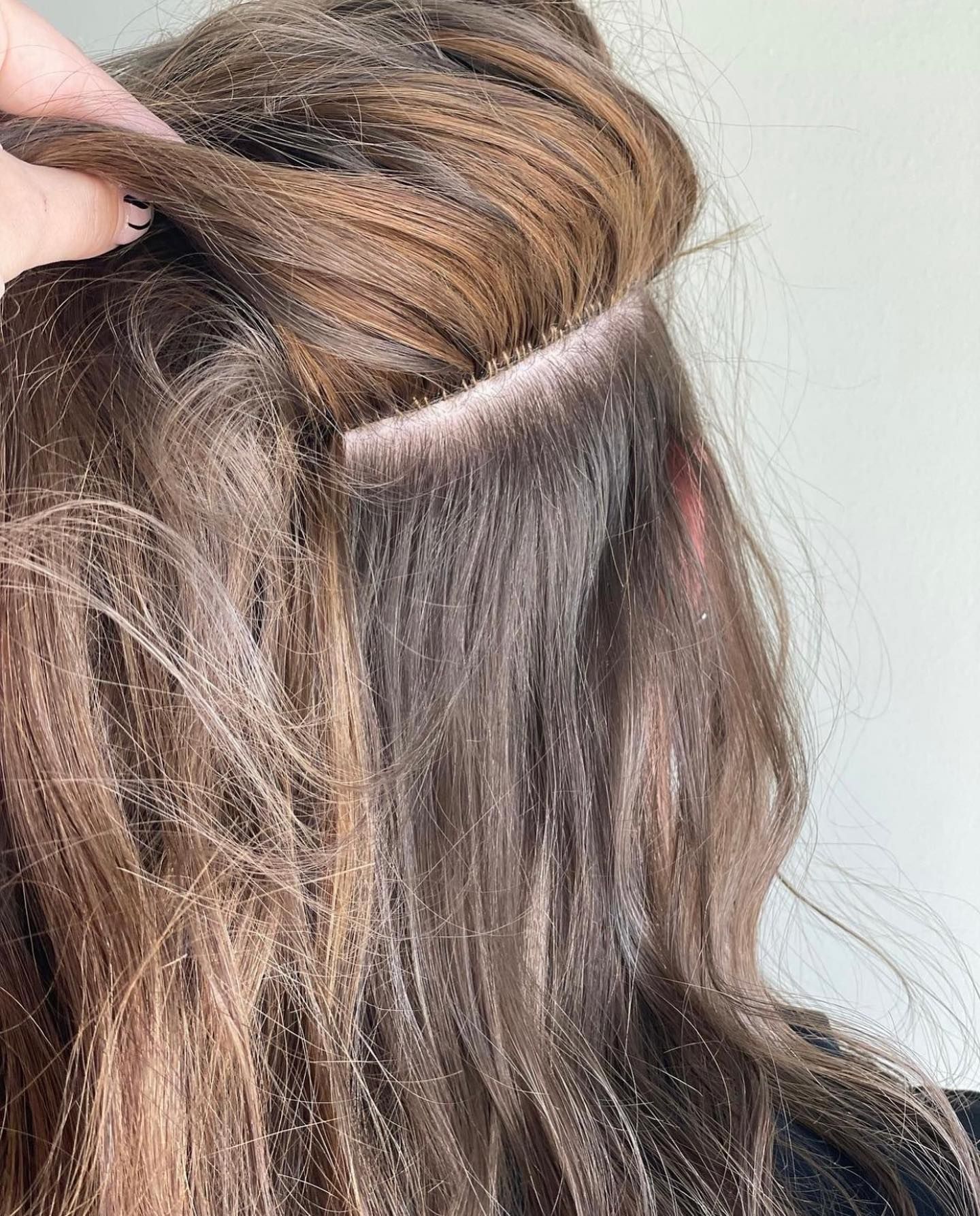 A close up of a woman 's hair with extensions in it.
