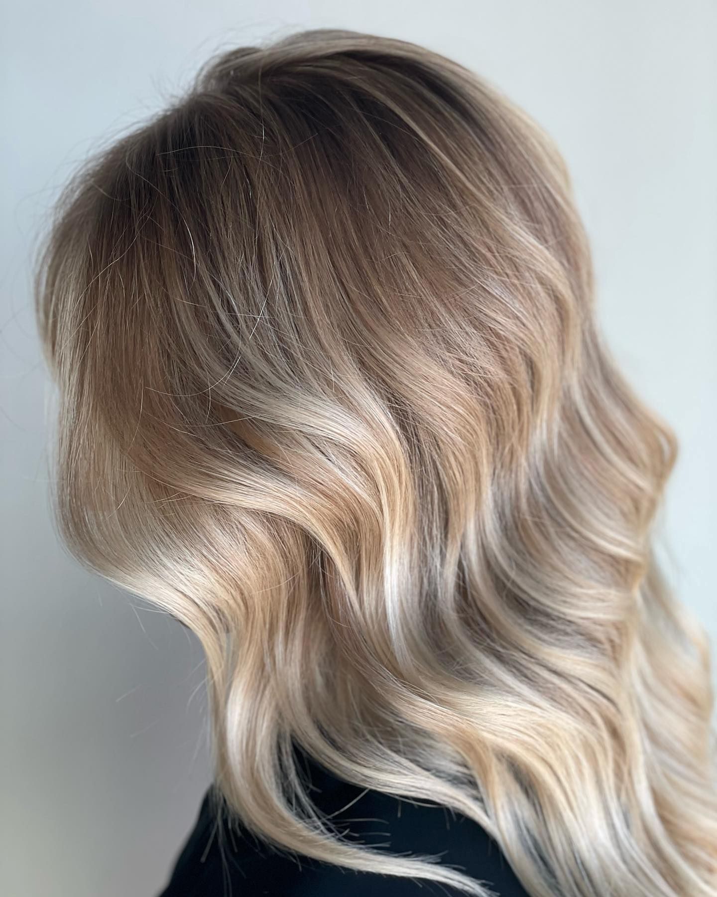 A woman with long blonde hair is wearing a black shirt.