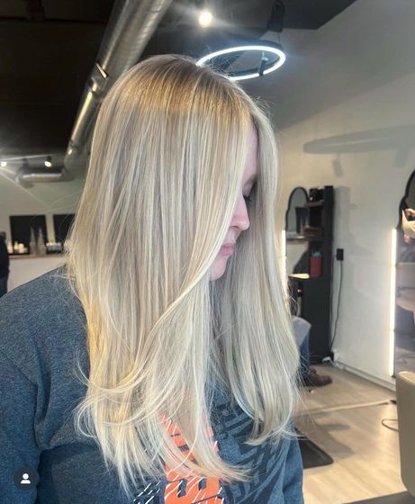 A white truck is parked in a parking lot next to a building.