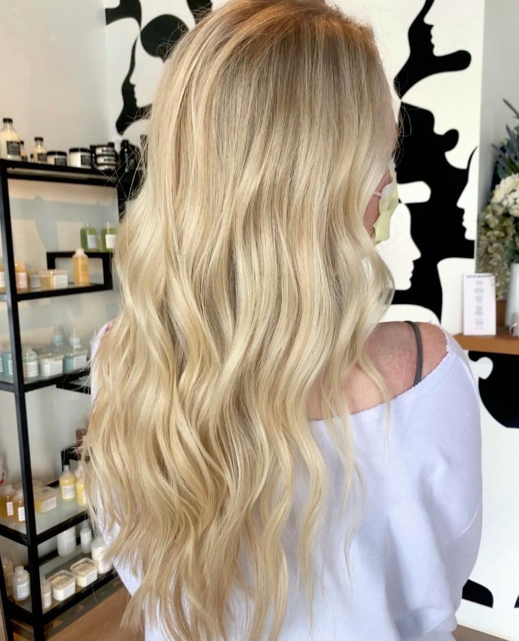 A white truck is parked in a parking lot next to a building.