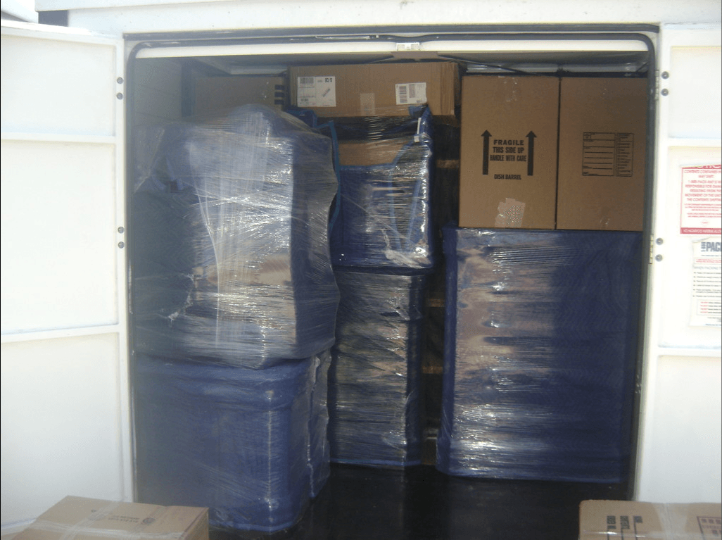 man arranging sofa inside the container van