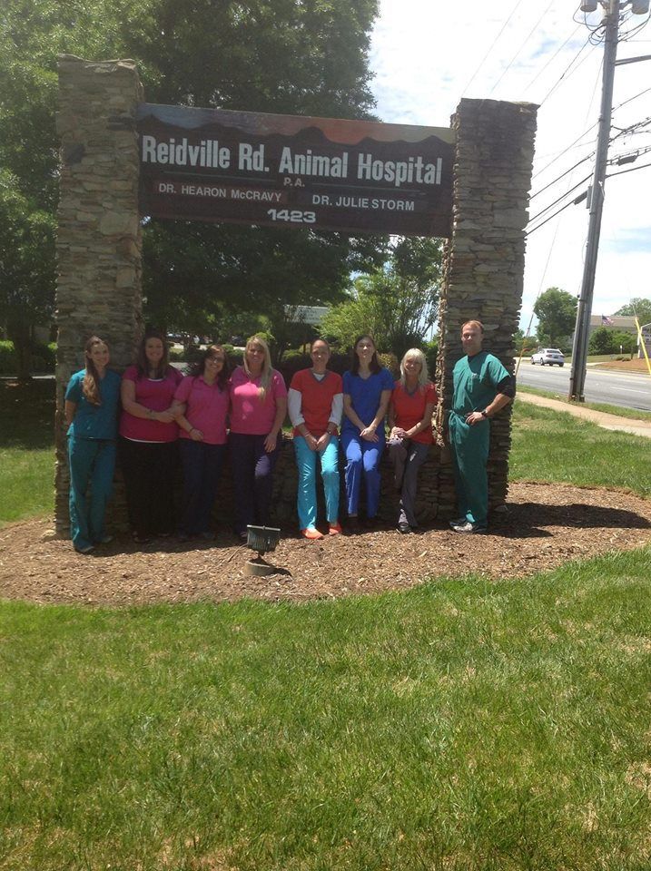 Reidville Rd. Animal Hospital staff standing under their sign in front of the building