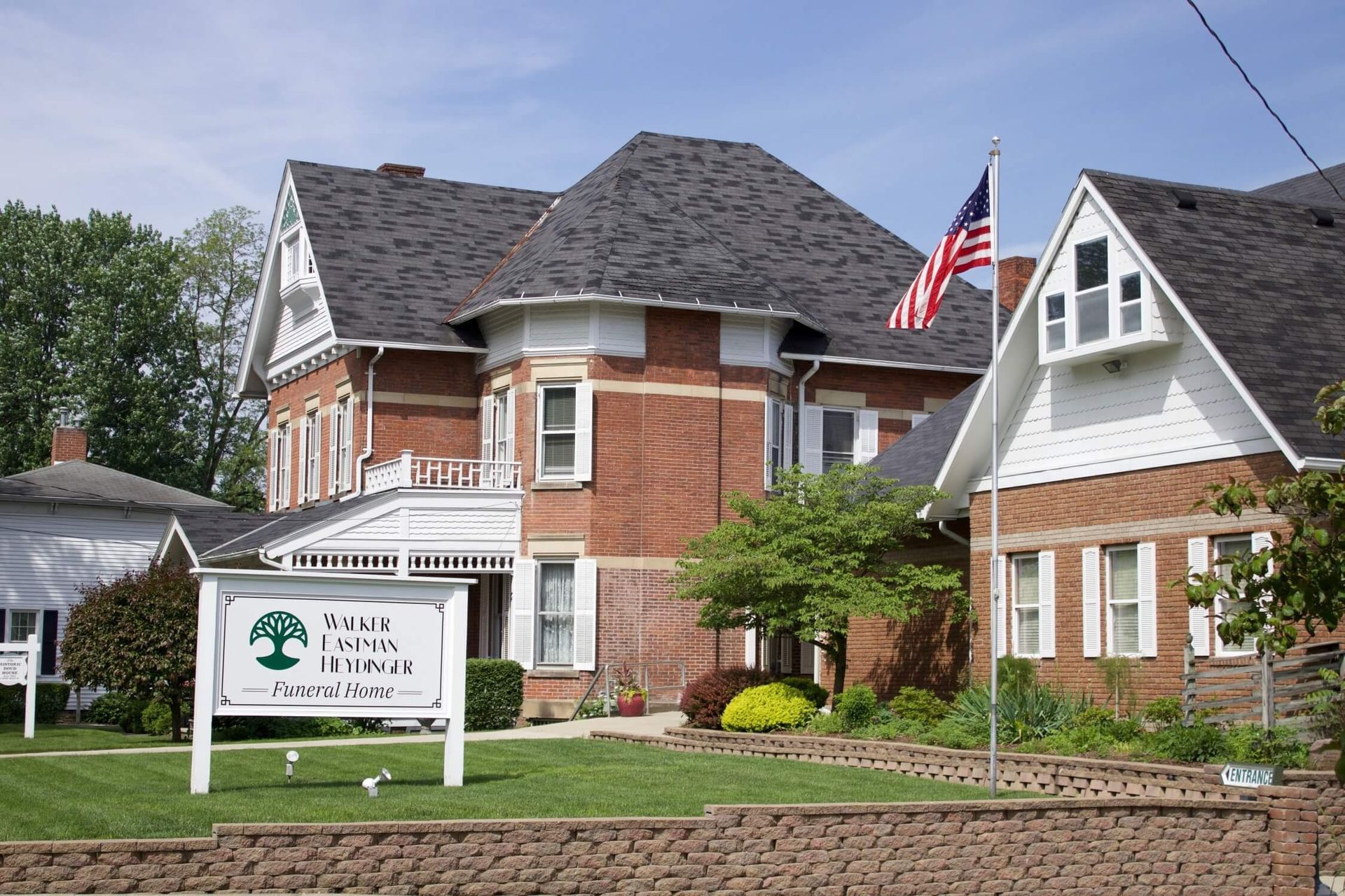Brick building with sign for Apple Creek Inn, American flag.