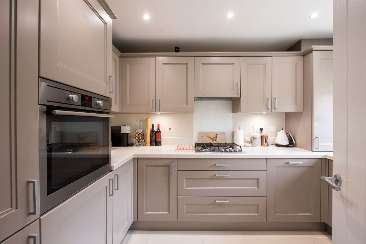 A kitchen with a stove , oven , sink , and cabinets.