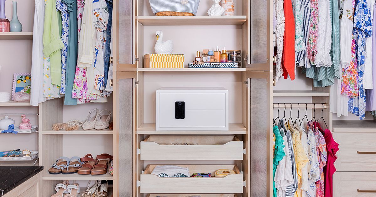 Closet interior with shelves, clothing, shoes, and a white safe.