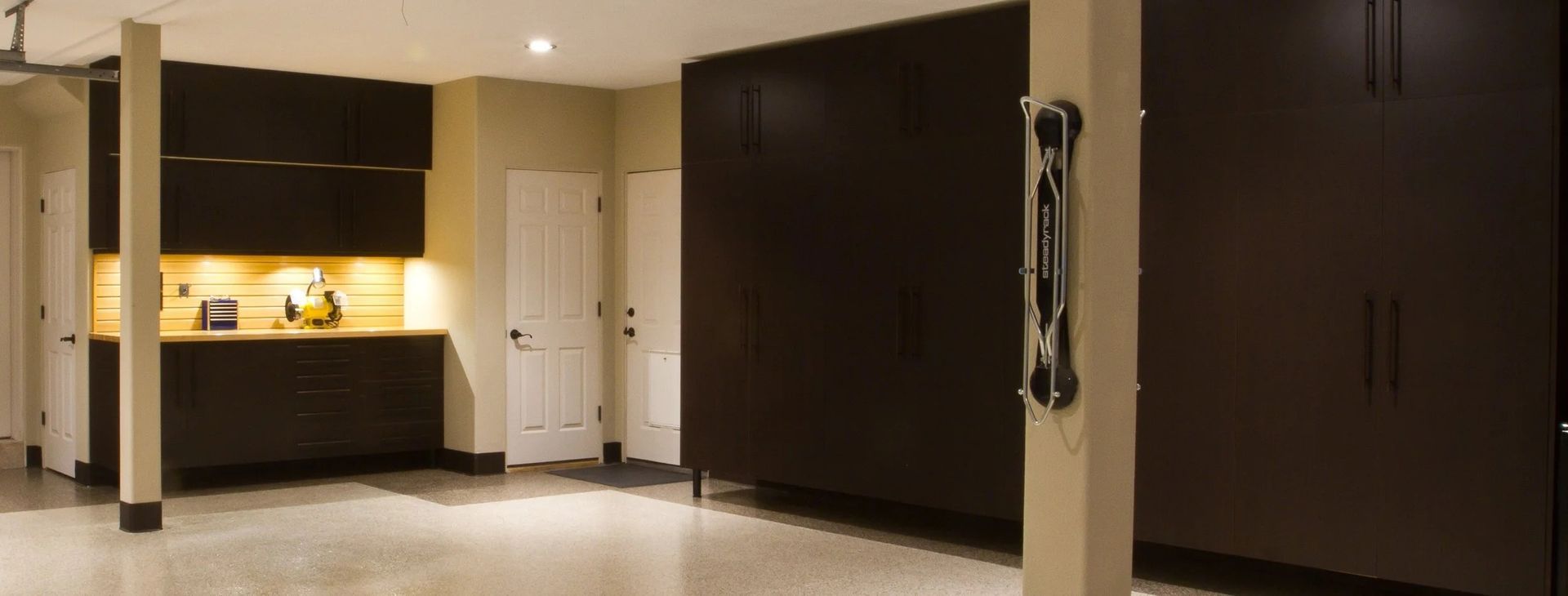 Garage interior with dark cabinets, a work area, and storage.