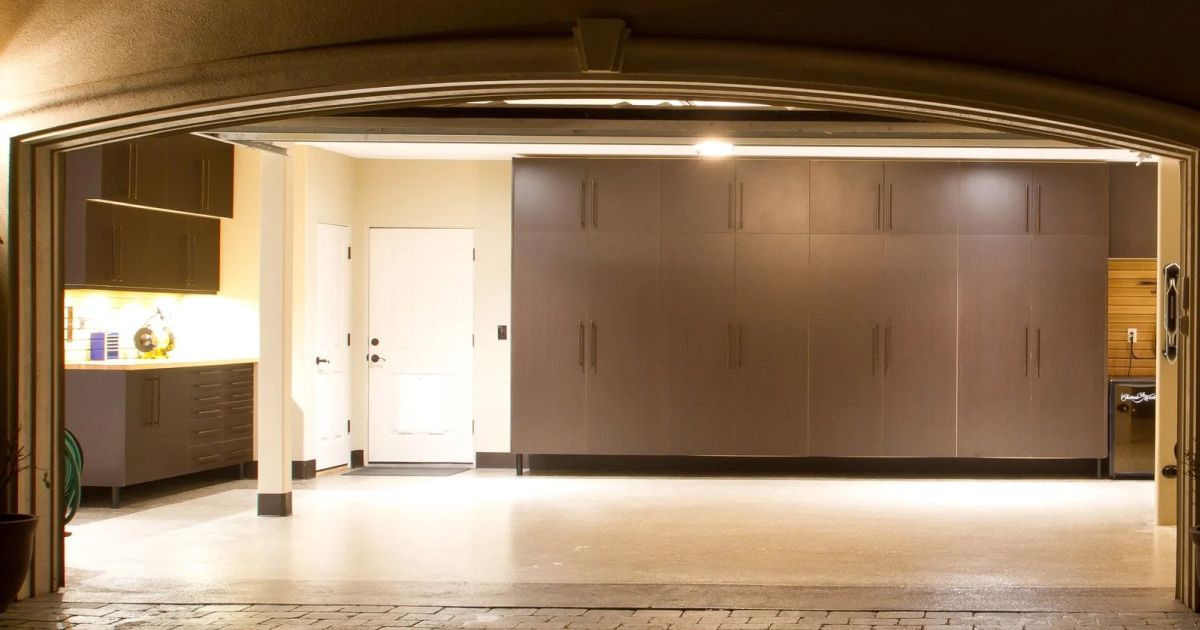 Inside view of a garage with brown cabinets, a white door, and an open door frame.