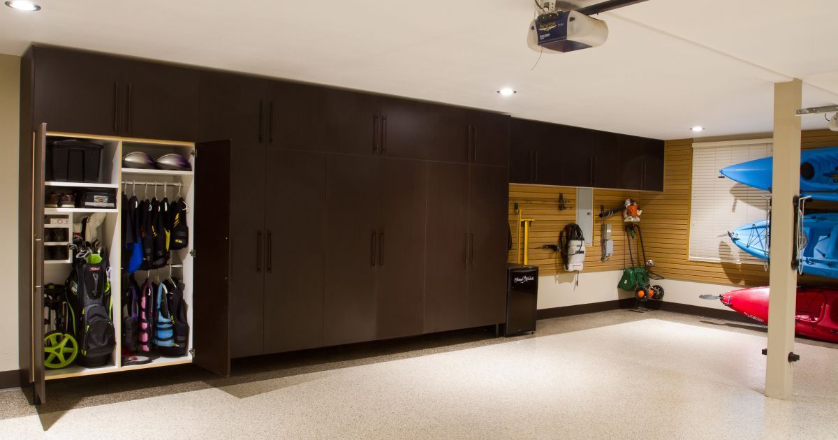 Garage with dark cabinets, open shelving, and kayaks.
