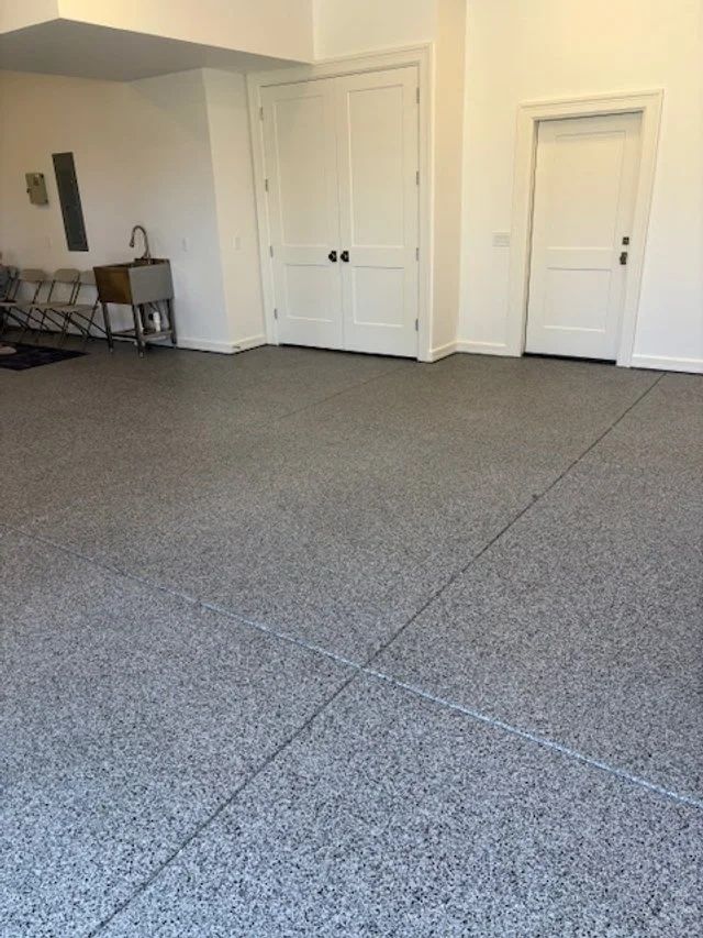 Garage with gray epoxy floor, white doors and walls.