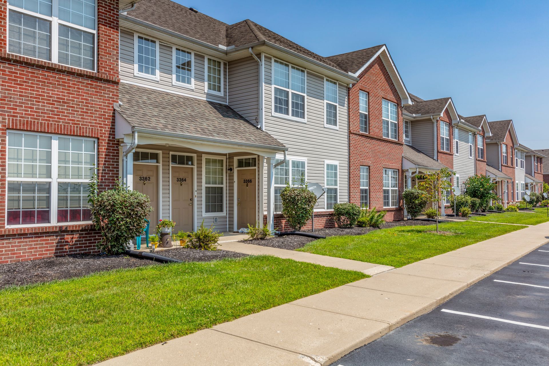 An exterior view of a row of buildings and parking lot.