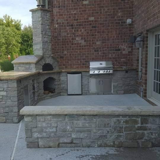 A car is parked in front of a house with a patio in front of it.