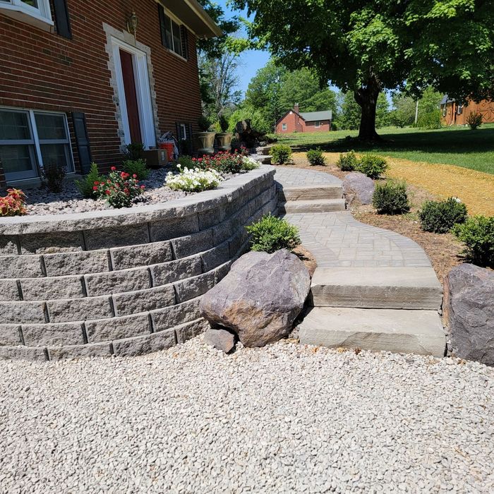 A brick walkway is being cleaned with a pressure washer.