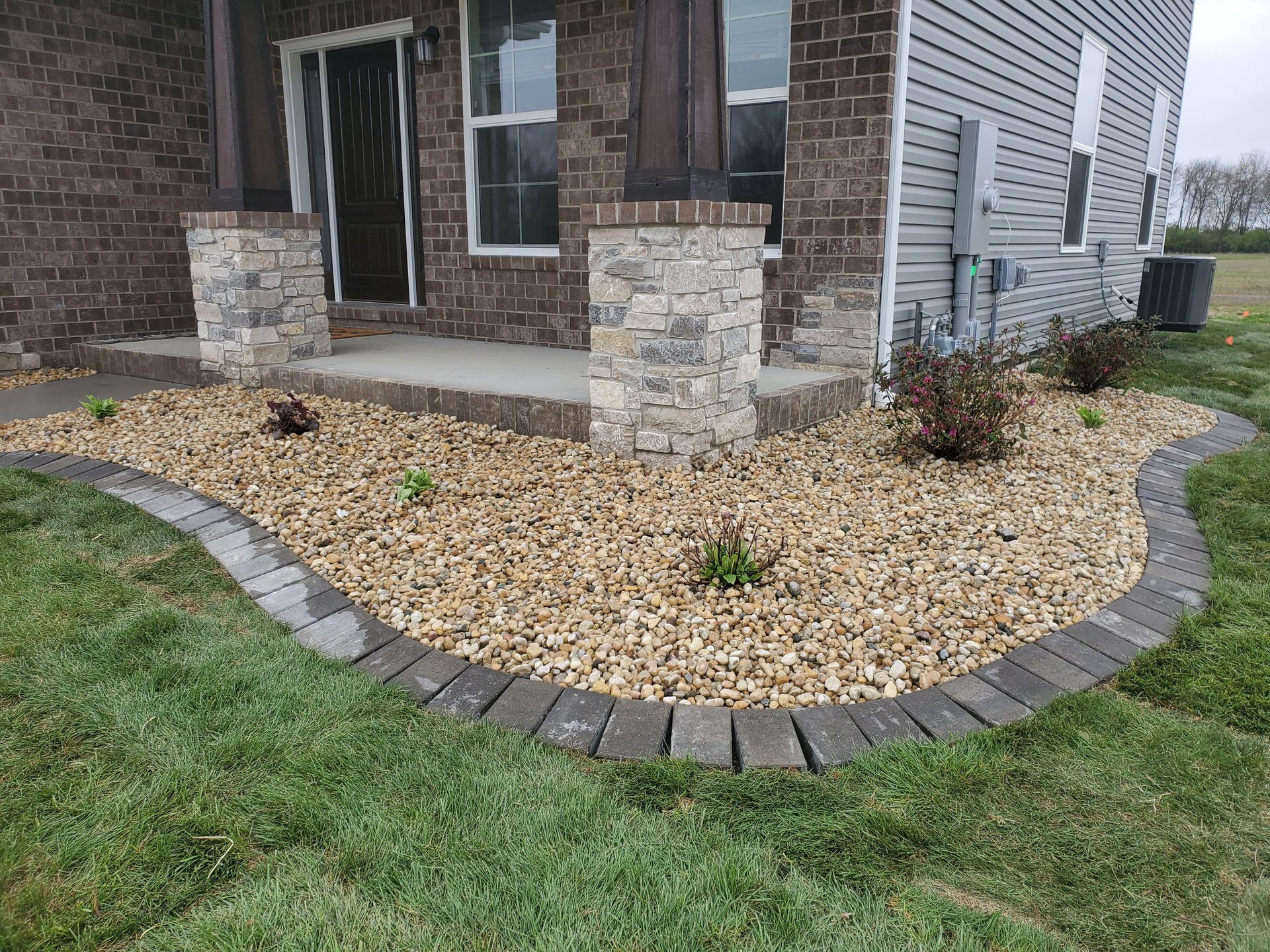 A brick house with a gravel walkway in front of it.