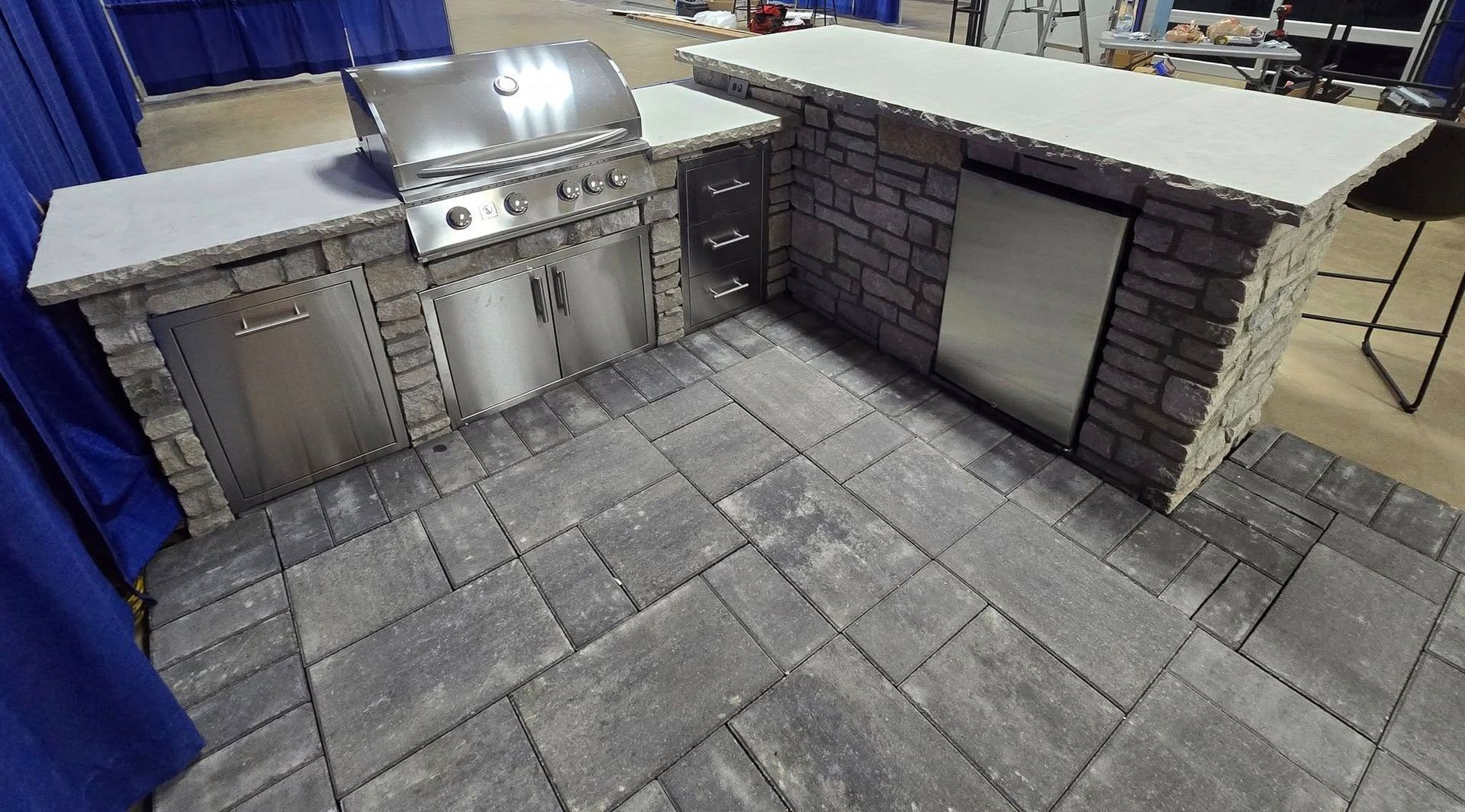 A kitchen with a grill and a counter in a room with blue curtains.