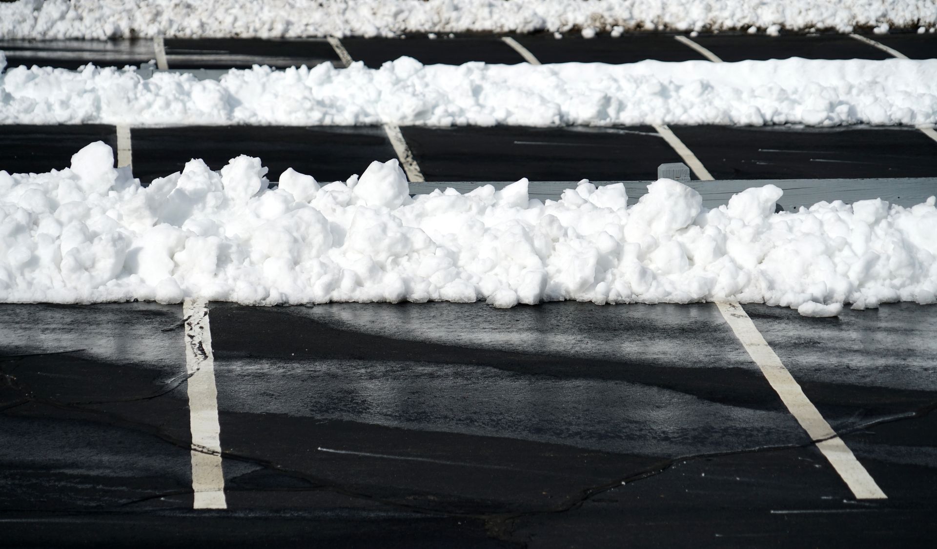 A yellow snow plow is clearing snow from a road.