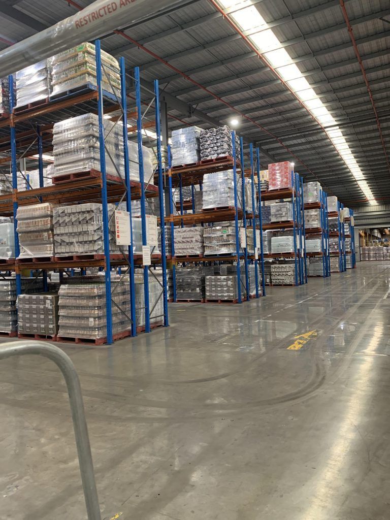 A large warehouse filled with lots of shelves and pallets.
