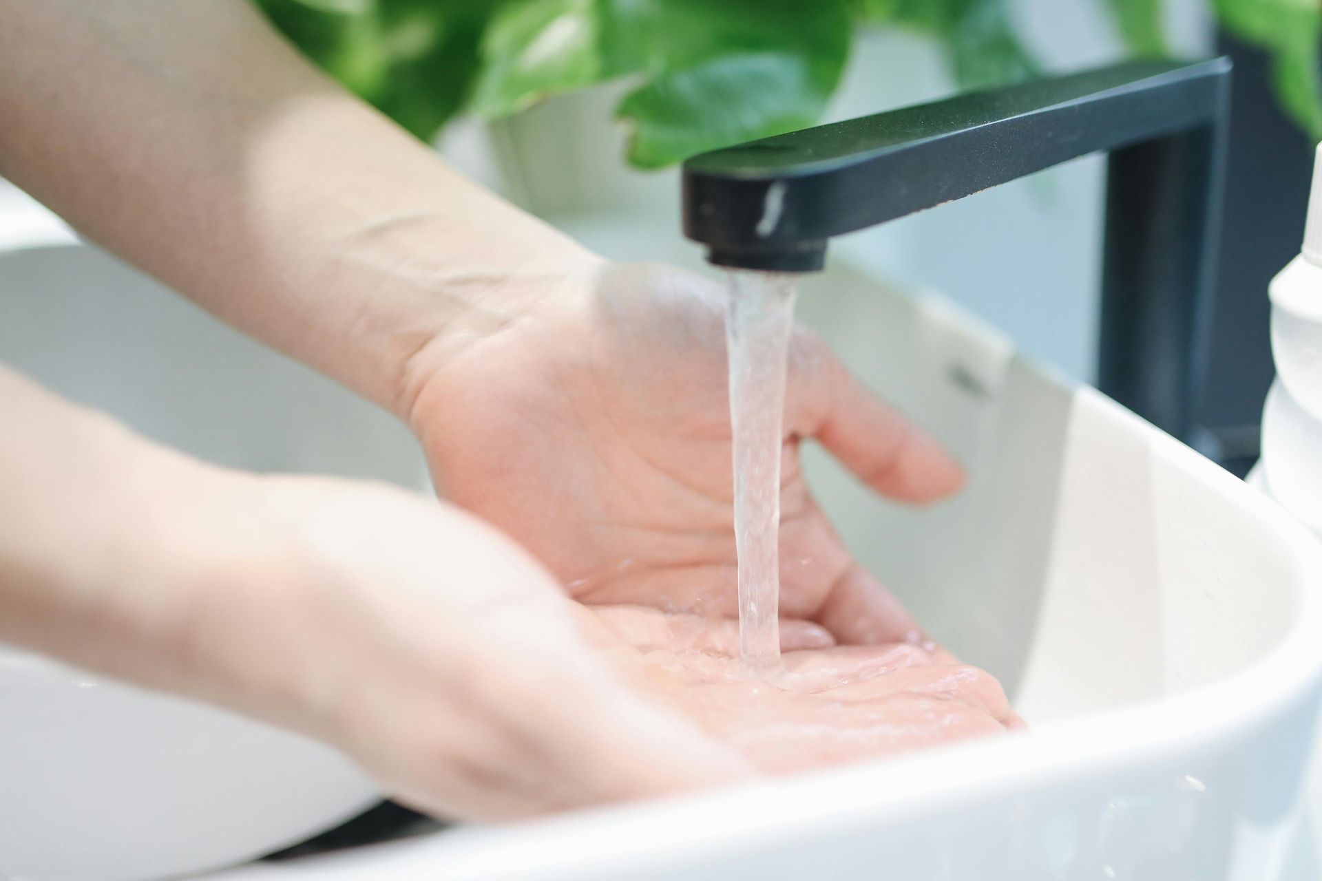 A person is washing their hands in a sink.