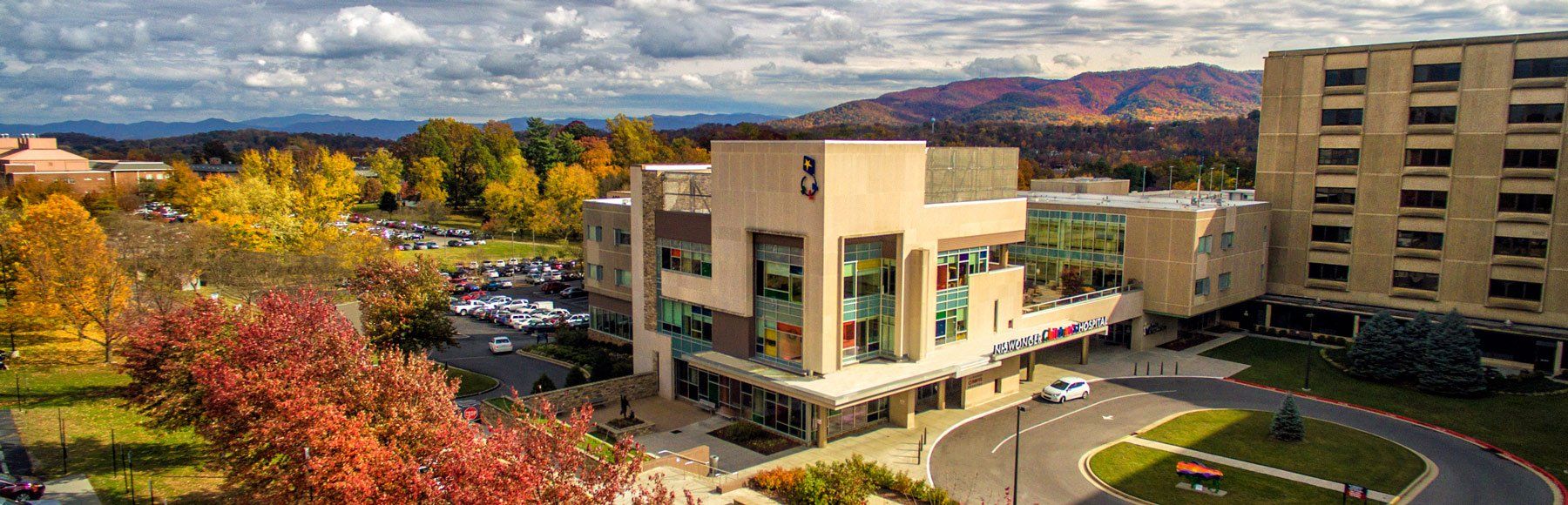 An aerial view of a large building with mountains in the background.