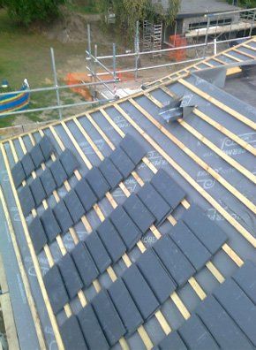  Roofing work in progress - new tiles being placed on timber frame
