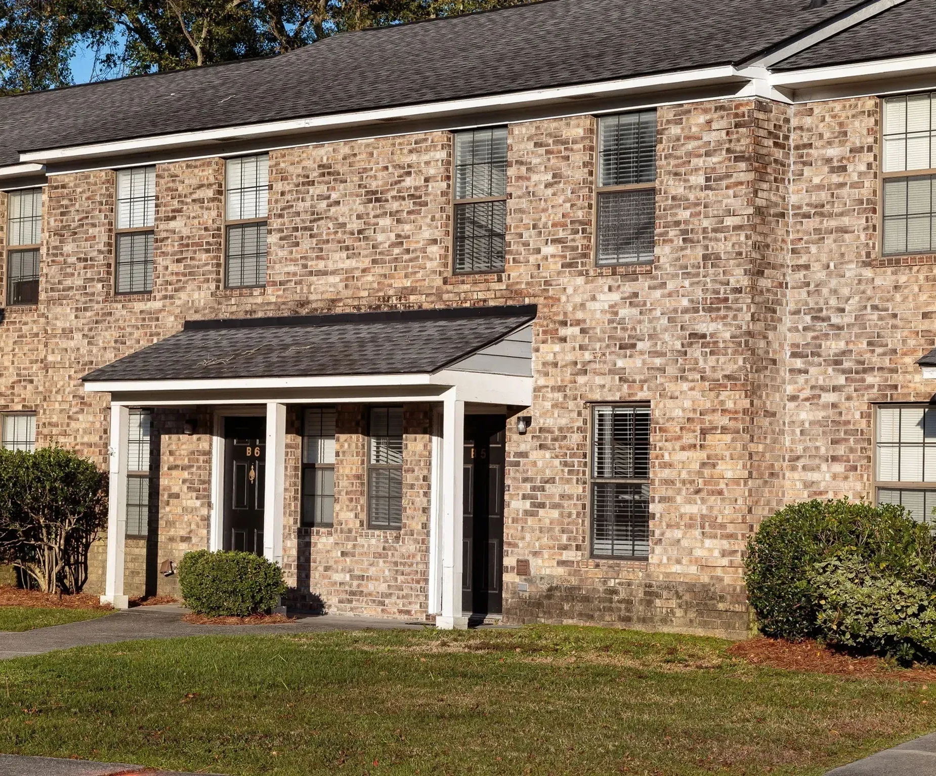 Exterior view of a brick apartment unit with two front doors