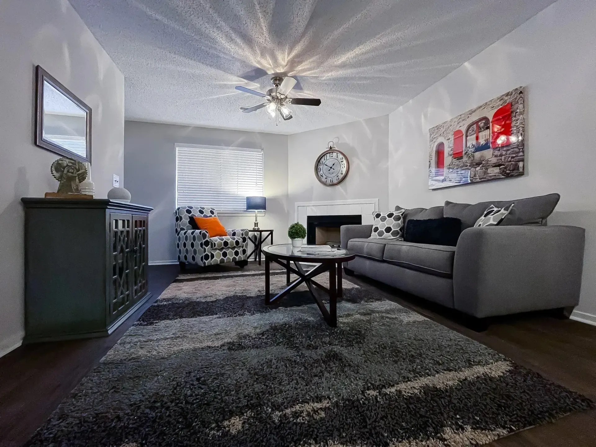 Modern living room with gray sofa, decorative pillows, and large window