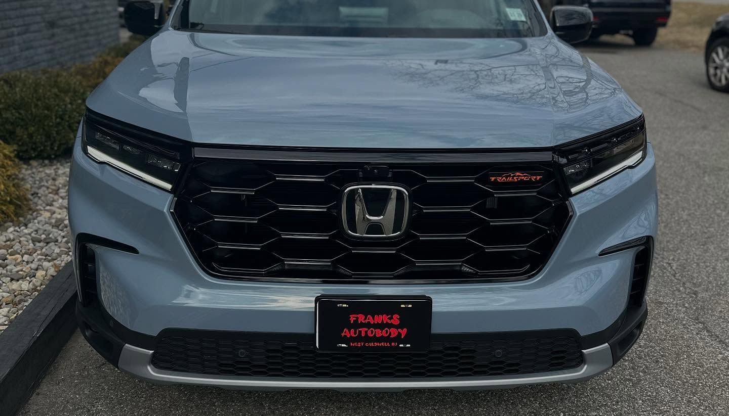 Black BMW car, close up of front, showing headlight, grill, and wheel.