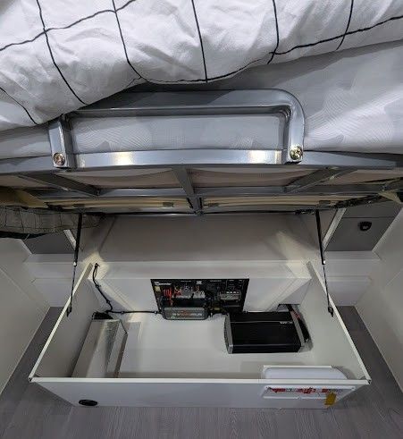 Open storage compartment under a bed. Contains electrical components. White interior. — Caravan and Trailer Clinic Geelong in Breakwater, VIC