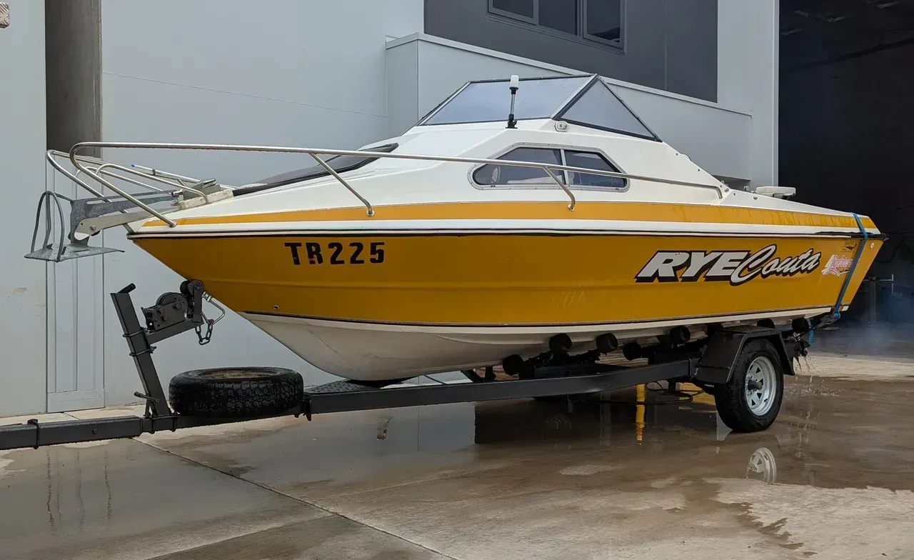 Yellow and white motorboat on a trailer, parked in front of a building. — Caravan and Trailer Clinic Geelong in Breakwater, VIC