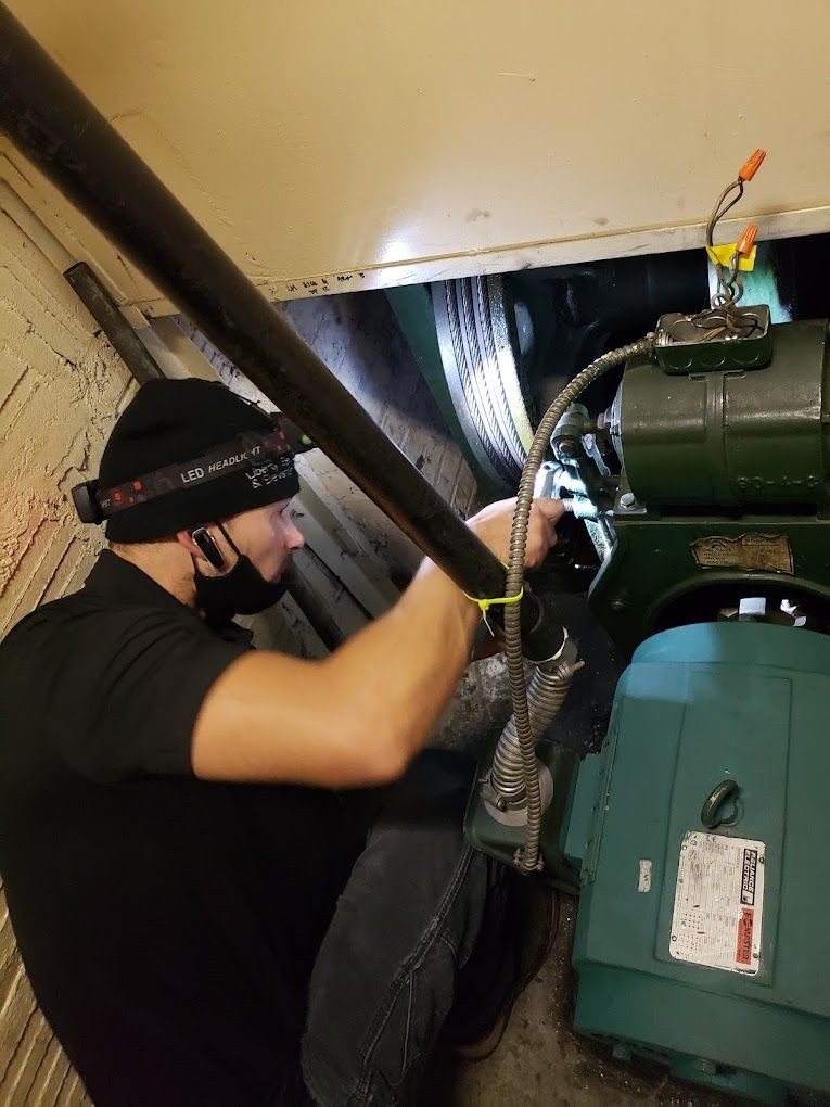 A man is measuring the height of an elevator with a tape measure.