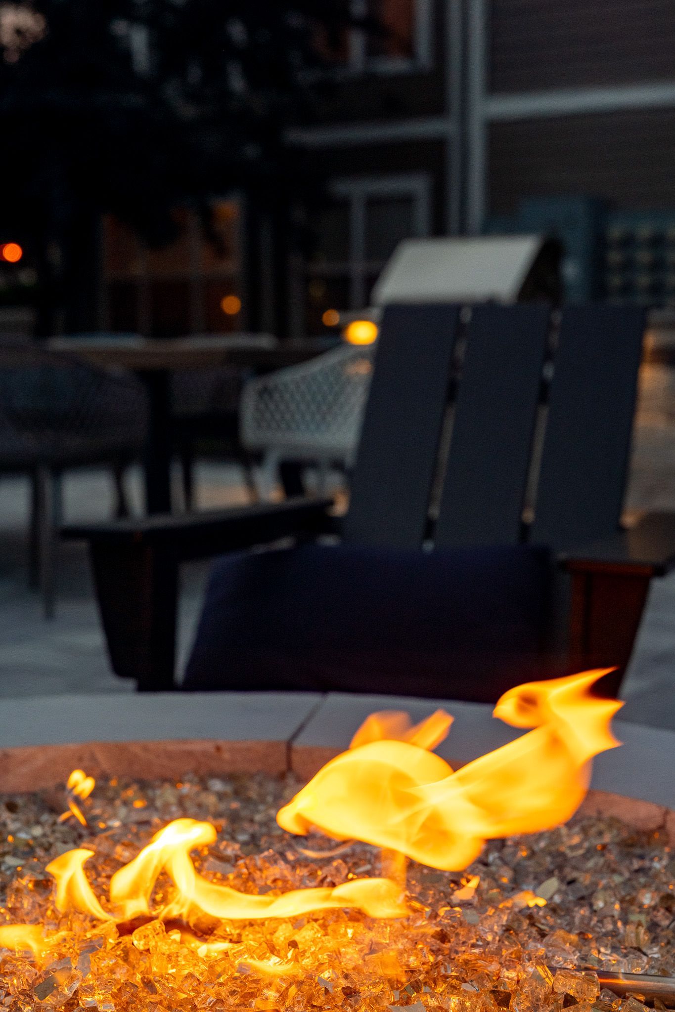 A fire pit with a chair in the background at Maple Knoll Apartments.