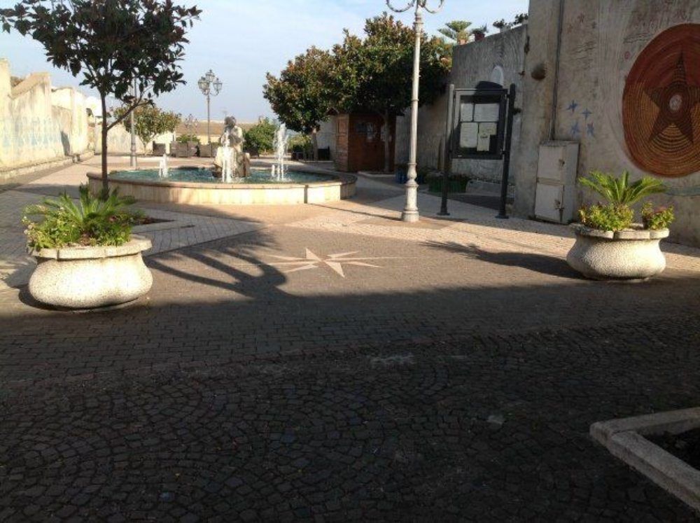piazzetta con pavimentazione in granito scuro e decorazione