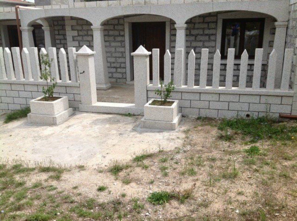 muretto e colonne in granito fuori da un'abitazione