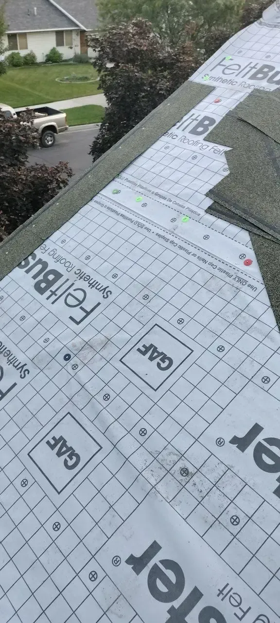 Roofing underlayment and shingles on a house roof. GAF logo is visible on the underlayment.