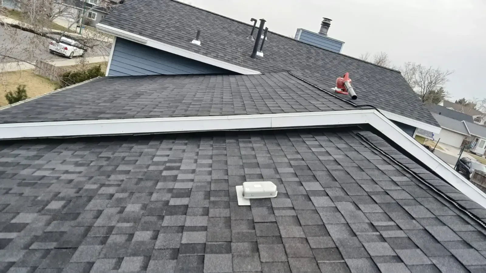 Dark gray shingle roof with a white vent, and the edge is a white trim; cloudy day.