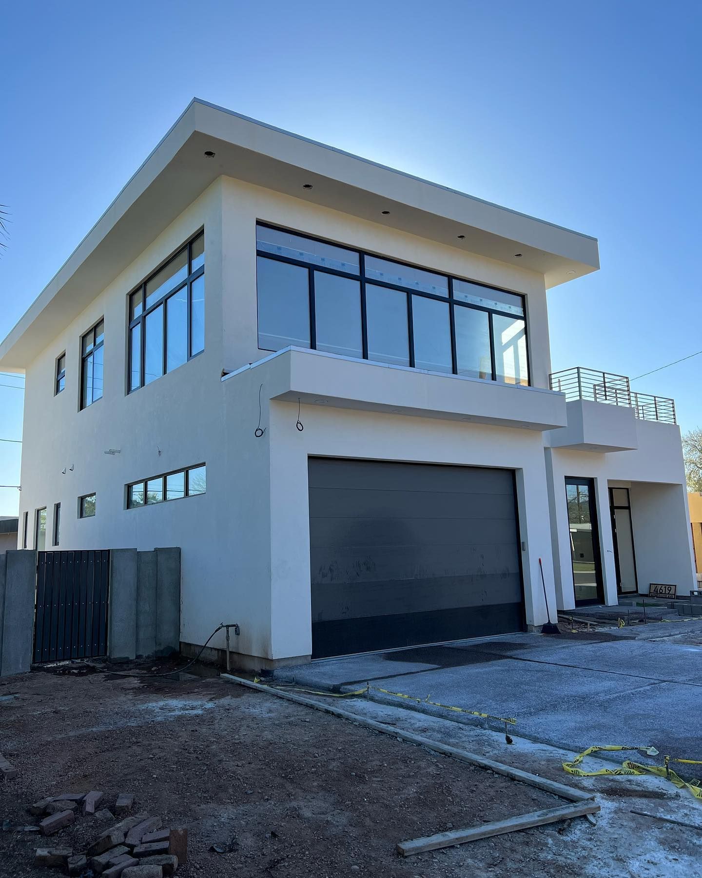 A large white building with a garage door and a balcony.