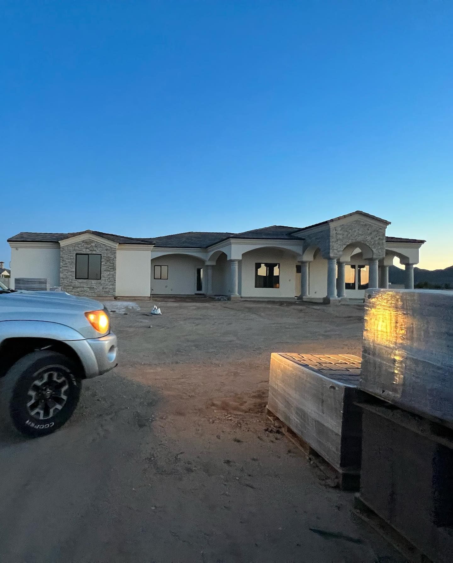 A truck is parked in front of a house under construction