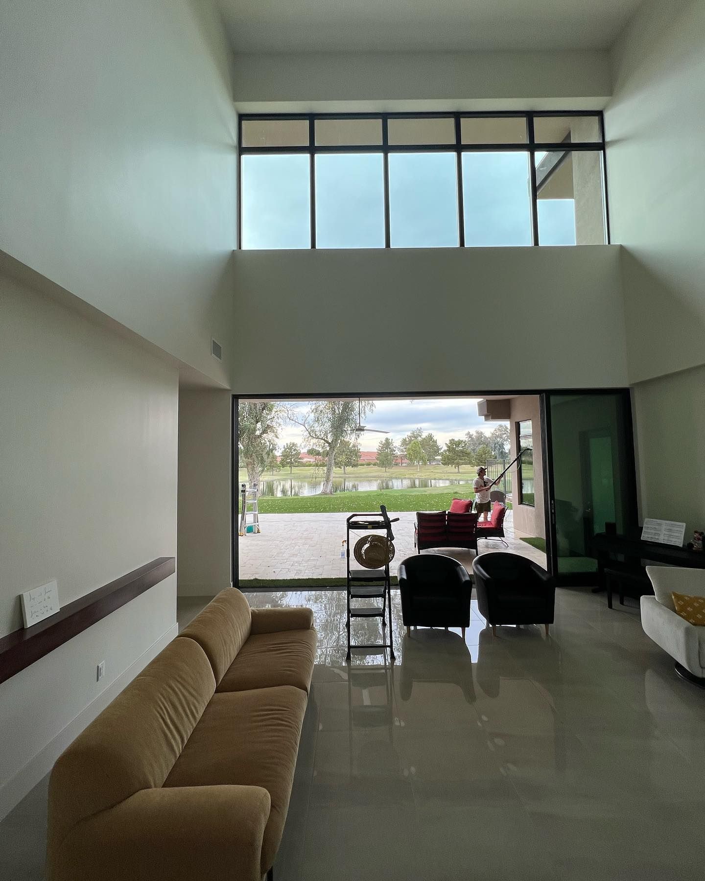 A living room with a couch and chairs and a large window