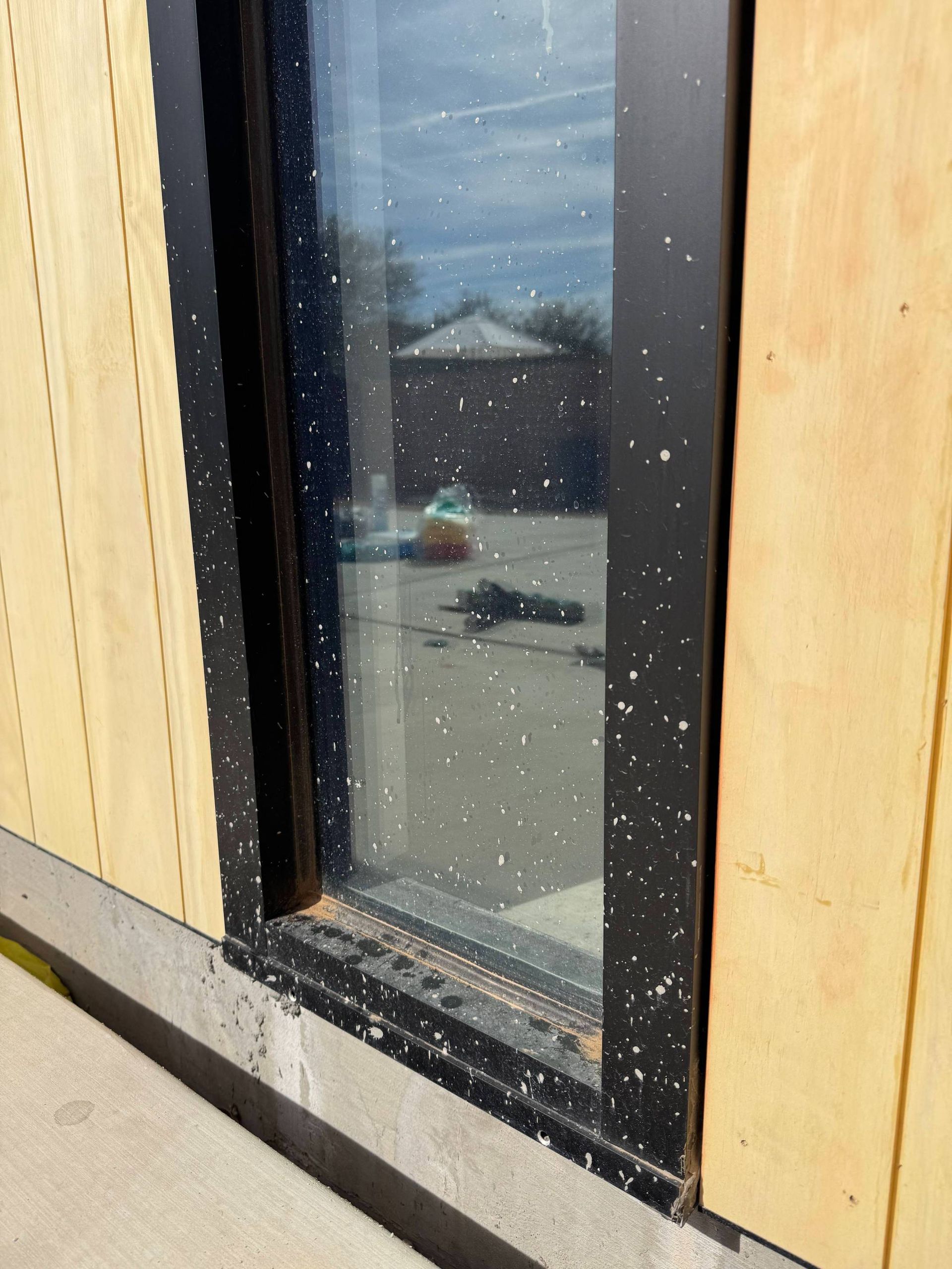 A black carpeted floor with a green pergola in the background