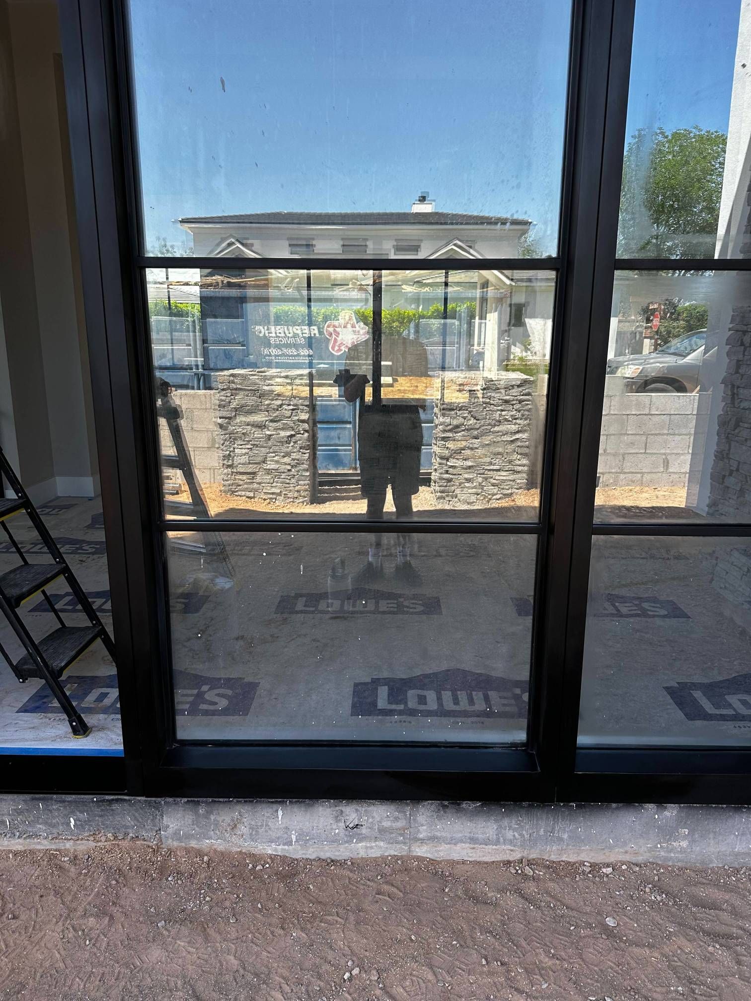 A dirty window with blinds on a brick wall