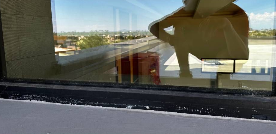 A dirty window with blinds on a brick wall