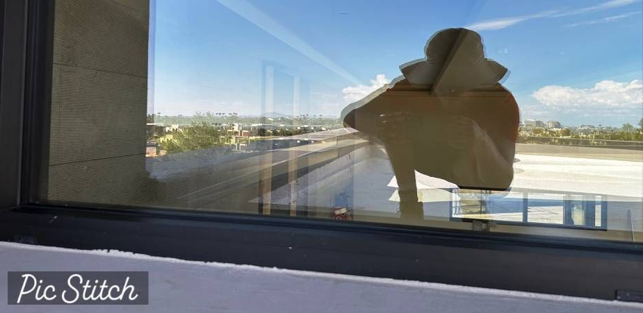 A window with blinds on it is on a brick building.