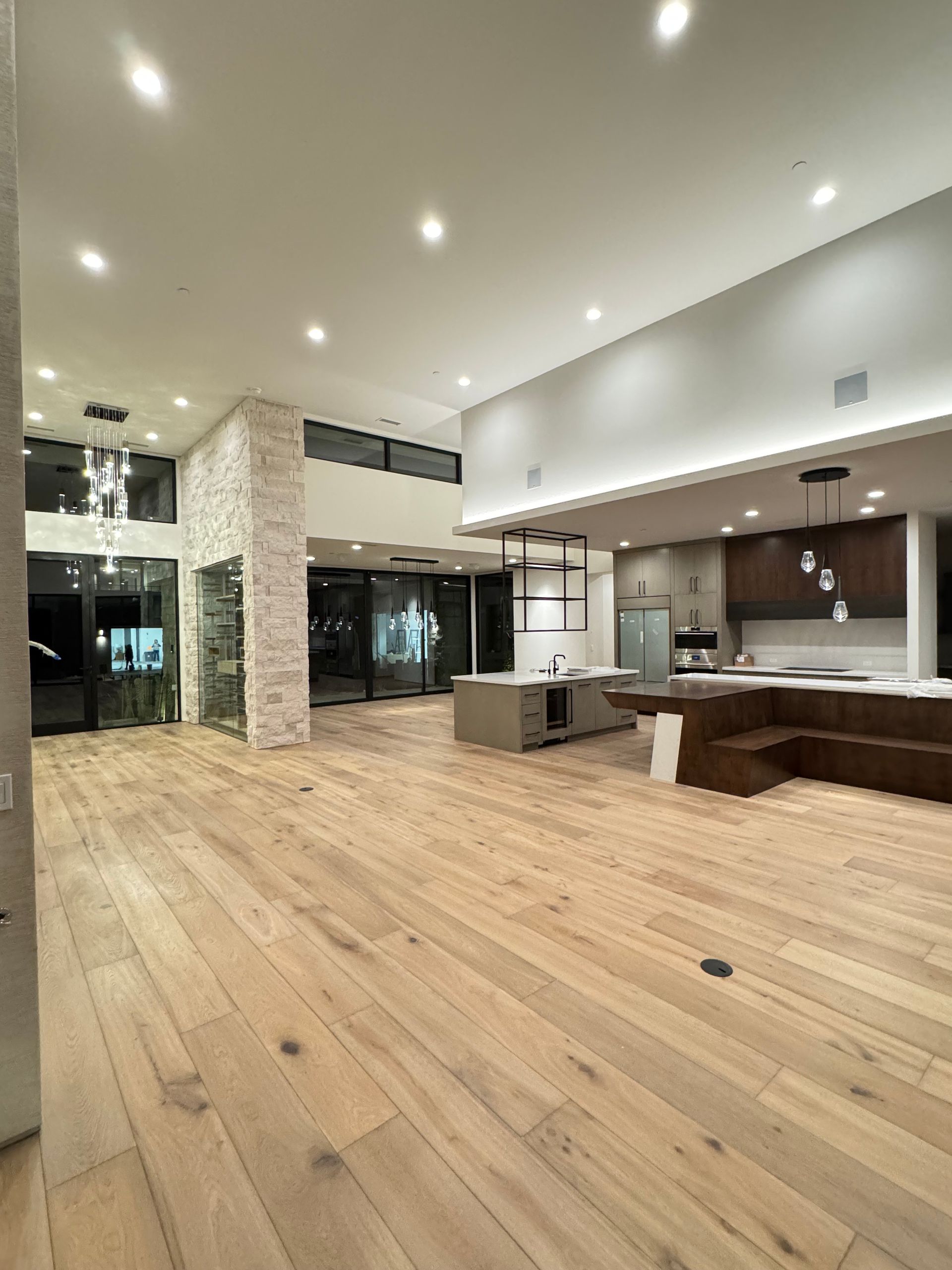 A large living room with hardwood floors and a kitchen.