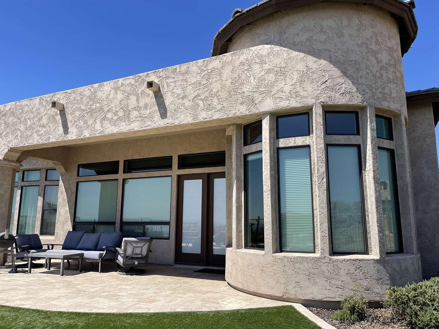 A large house with a lot of windows and a patio in front of it.