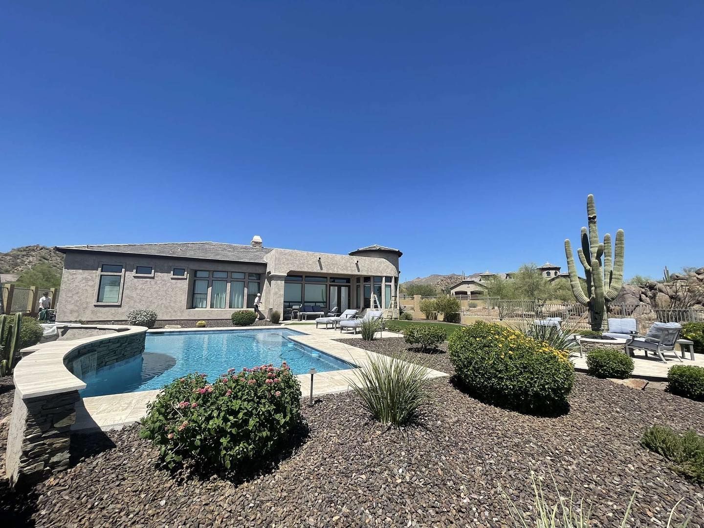 A large house with a large swimming pool in front of it.