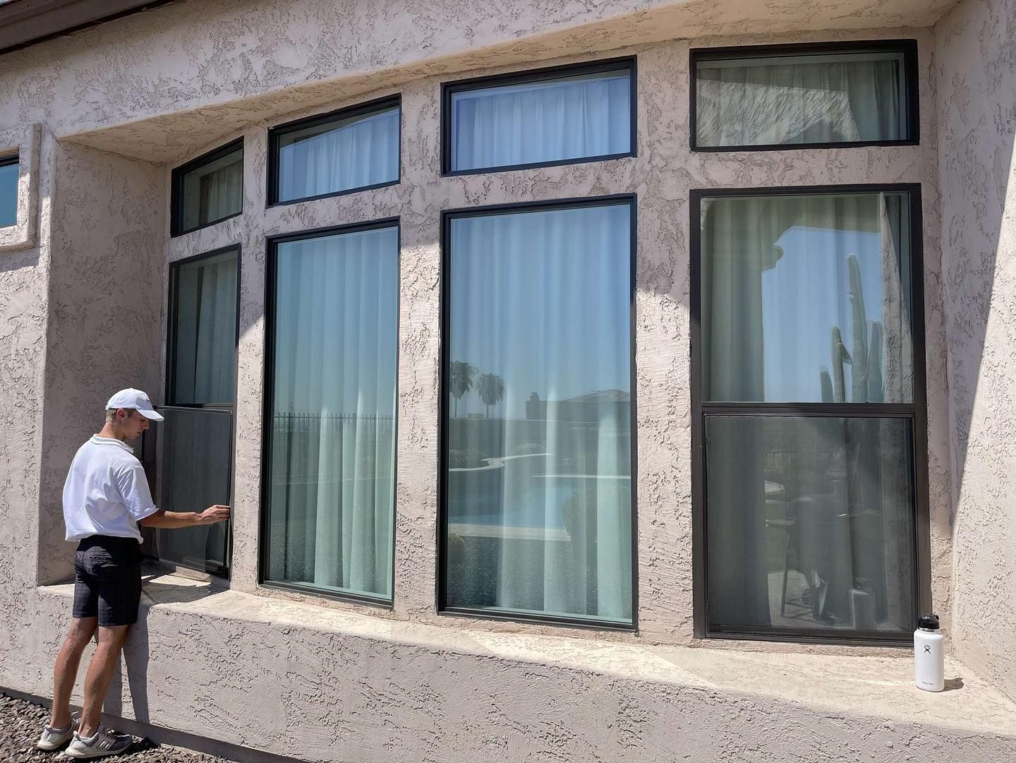 A man is cleaning the windows of a house.