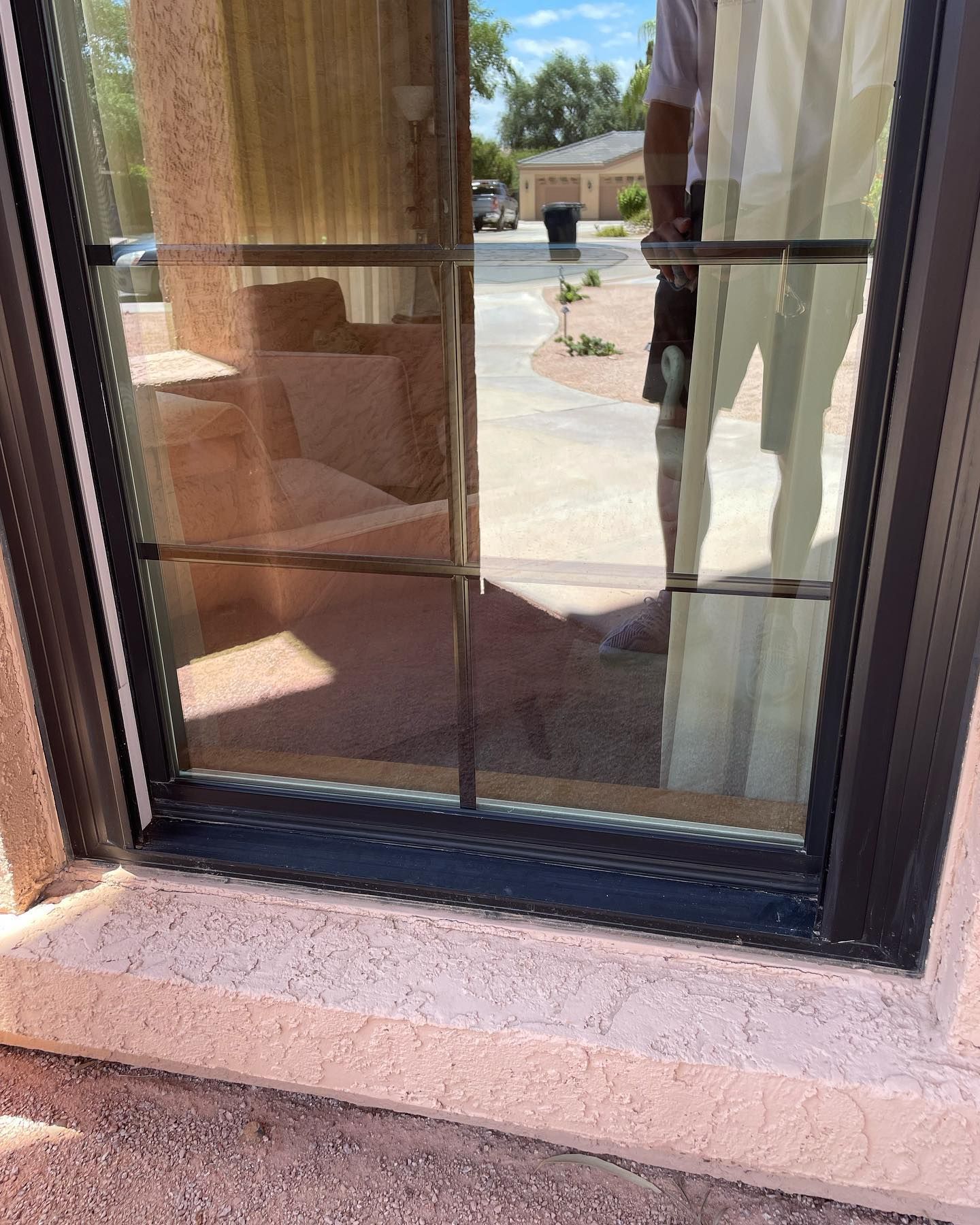 A man is standing in front of a window looking out.