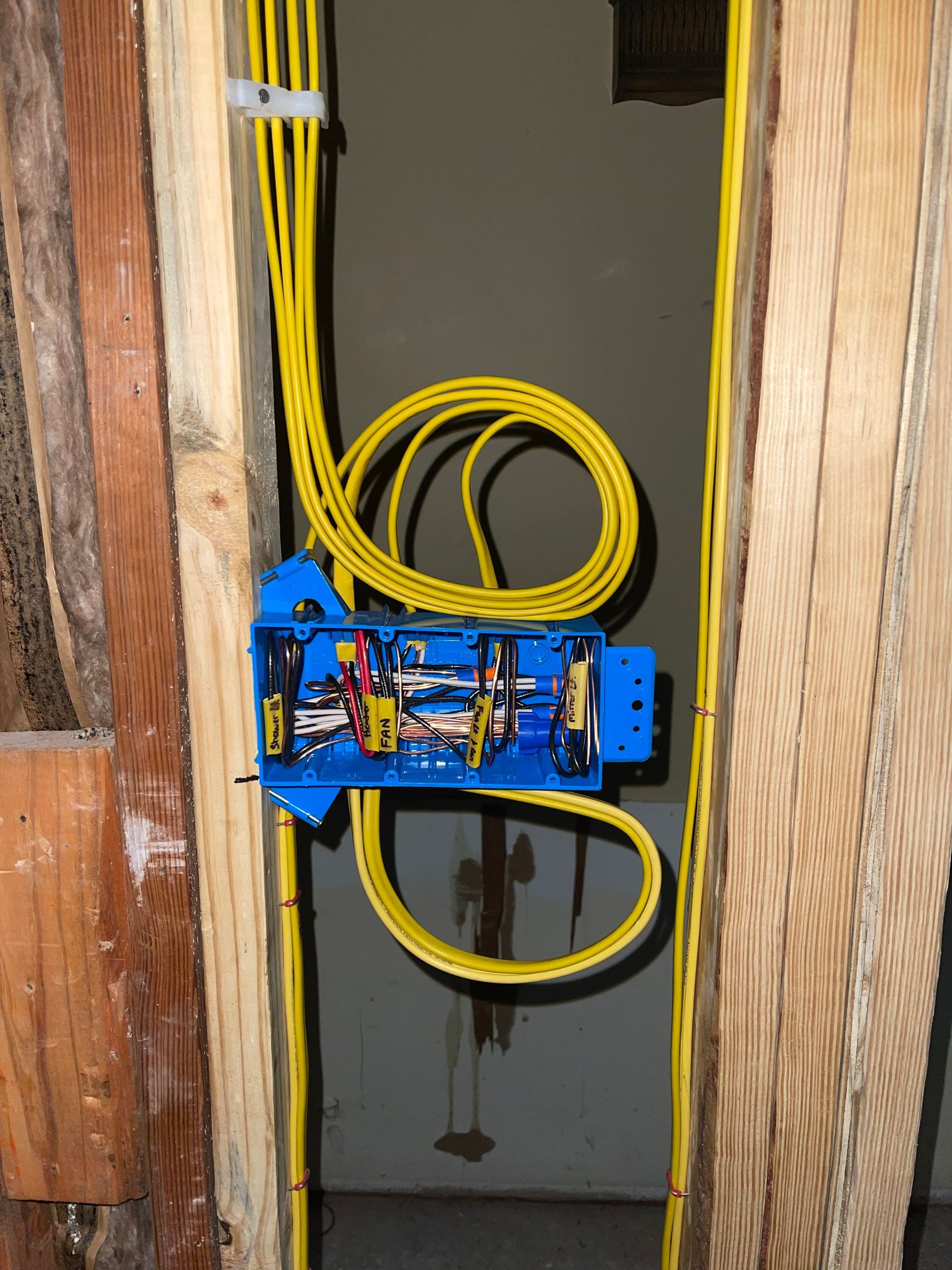 A wooden wall with electrical wires coming out of it.