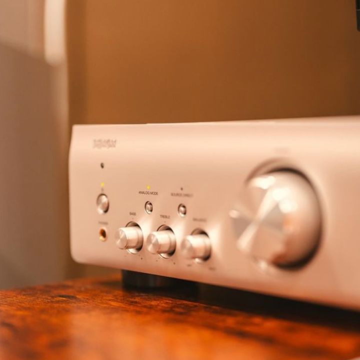 A White Amplifier is Sitting on a Wooden Table — Complete Audio in Maroochydore, QLD
