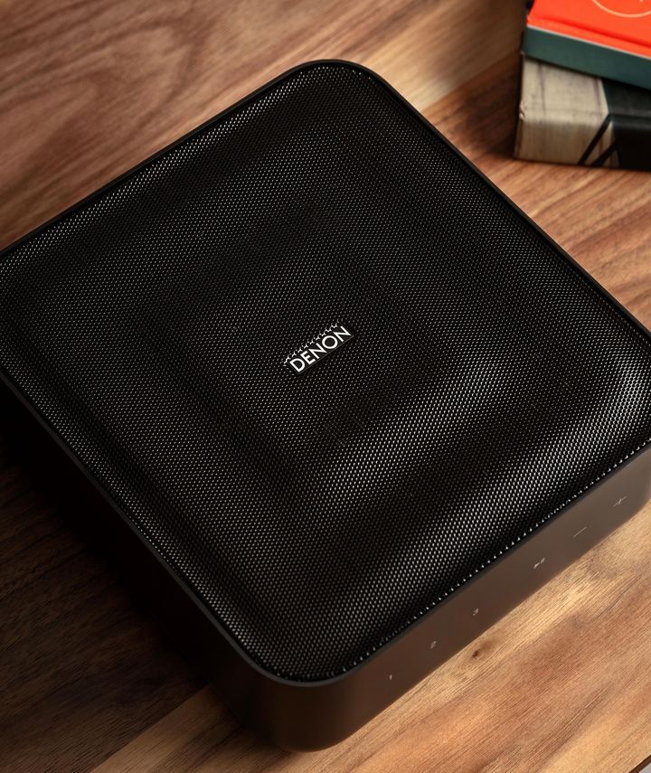 A Denon Speaker is Sitting on a Wooden Table — Complete Audio in Maroochydore, QLD