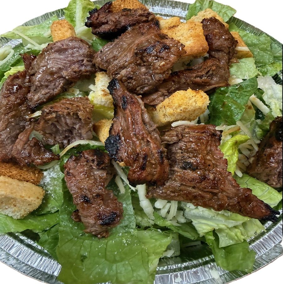 Caesar salad topped with fresh marinated steak tips